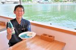 船内で提供される岩美ブルーサイダーと岩美ブルーカレーを持つ田中船長＝１２日、岩美町大谷