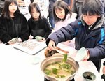 地元のワカメを湯がいて食べる児童ら