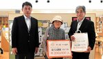 ２０万人目の来館者となった大坪さん（中央）