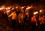 たいまつを手に大神山神社奥宮の参道を歩く参加者たち＝１日、鳥取県大山町大山