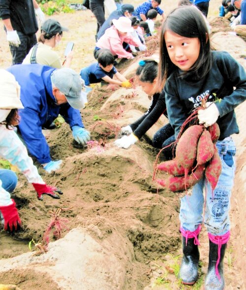 大物を収穫して満足そうな子ども