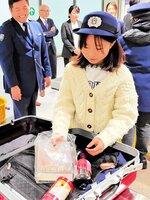 スーツケースの中から模擬薬物を捜し出す小学生