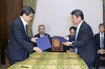 　９日、合意文書を取り交わす自民党の茂木幹事長（右）と公明党の石井幹事長＝国会