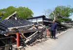 　能登半島地震で崩れた山門を指す日蓮宗本住寺の住職大句哲正さん＝５月、石川県珠洲市