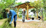 新設されたあずまやの周りで草刈りに汗を流す会員ら