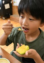 スプーンを使っておいしそうにメロンを食べる児童＝３０日、倉吉市の久米小