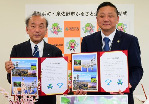 協定書に署名した宮脇町長（左）と千代松市長＝２７日、湯梨浜町役場