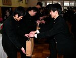 在寮生（右）から記念品を贈られる卒寮生