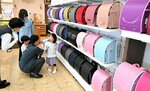 背負い心地や色などを吟味しながらランドセルを選ぶ家族連れら＝４月３０日、鳥取市湖山町東３丁目の人形のはなふさ鳥取店