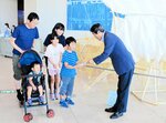 ２万人目となり藤間館長（右）から記念品が贈られた桂さん一家