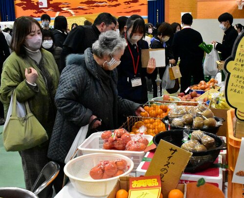 地元の野菜や果物を買い求める客に丁寧に接客する生徒（中央）ら＝２日、鳥取市湖山町北２丁目の鳥取商業高