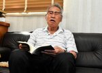 戦争体験をつづった自著を片手に当時を振り返る宮本さん＝３日、若桜町若桜