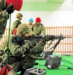 集中して約２００㍍先の的を狙う自衛官候補生＝９日、米子市河崎の米子射撃場