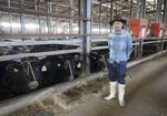 　被災した牛舎に立つ牧場主の平林将さん＝石川県能登町