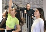 　レッスンを見守る「沖縄アクターズスクール」創業者のマキノ正幸さん（奥）＝２０１８年９月、沖縄県北谷町