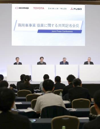 　２０２３年５月、経営統合に関し記者会見する（壇上左から）日野自動車、トヨタ自動車、ダイムラー・トラック、三菱ふそうの４社の社長＝東京都内のホテル
