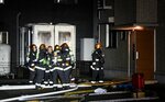 火元とみられる居室を調べる消防隊員ら＝８日午後７時１０分ごろ、鳥取市安長
