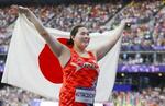 　女子やり投げで金メダルを獲得し、日の丸を掲げる北口榛花＝パリ郊外（共同）