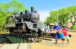 転車台に乗ったＳＬを手動で回転させる子どもたち＝若桜鉄道若桜駅