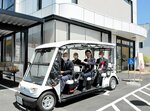 送迎用に導入した７人乗り電動車に試乗する関係者ら＝２２日、米子市永江のコミュニティーセンターりんＲＩＮ