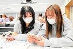 相談しながら税金クイズに答える学生