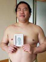 　故北の湖親方（元横綱）の写真を手にする。いつも枕元に置く「お守り」だ＝２０２４年４月、東京都江東区の山響部屋