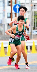 １区大下（奥）からたすきを受けた２区山本圭が区間５位の走りで順位を五つ押し上げる＝第１中継所