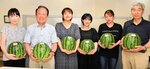 スイカを受け取った学生らと県人会関係者