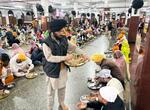 　来訪者にチャパティを配る男性＝２０２５年３月、インド・アムリツァル（共同）