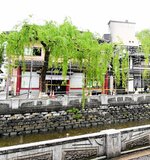 火事で焼けた旅館では焼け残った建物の外壁が落下しないようにフェンスの設置作業が進む＝９日、豊岡市城崎町湯島