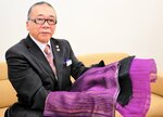 紫草染めのストールを手にする石川さん