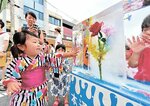 涼しげな「花入り氷柱」を触って楽しむ子ども＝２０１７年、鳥取市の本通商店街