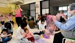 曲に合わせてスカーフで触れ合う音楽療法の様子＝５月下旬、八頭町郡家殿の同町子育て支援センター