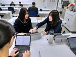 　ＡＩ活用のアイデアをまとめた資料作成について、話し合う山形市立商業高の生徒＝２０２４年１２月