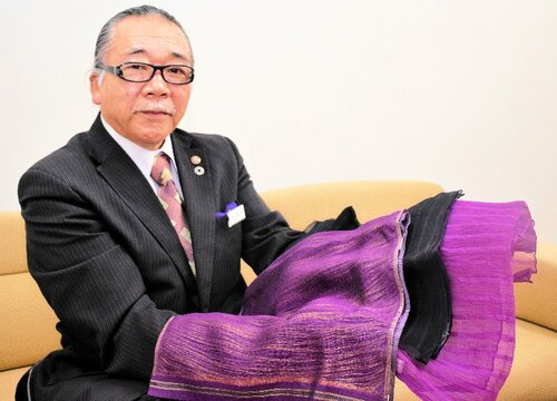 紫草染めのストールを手にする石川さん