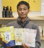 　自社製品のポン菓子を手にする沢田米穀店の沢田導俊さん＝４月、北海道北斗市