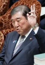 　衆院予算委の集中審議で答弁のため手を挙げる石破首相＝１２日午前