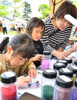 グラスプレート作りに挑戦する家族＝６日、米子市公会堂