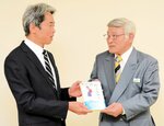出版した本を中井本部長（左）に手渡す山口さん