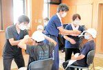 三角巾を使った頭部の応急手当てを学ぶ受講者ら