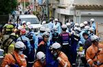 　消防隊員や警察官で騒然とする、複数の子どもが車にはねられた事故現場＝１日午後２時３２分、大阪市西成区
