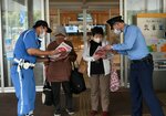 買い物客にチラシを配って事故防止を呼びかける参加者ら＝１６日、鳥取市鹿野町岡木の道の駅西いなば気楽里