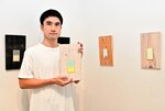シンプルな美しさが魅力の紙片が並ぶ会場と西堀さん