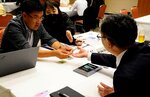 商談会で県内企業の製品サンプルを確認する韓国の医療機器関連企業の担当者（左）＝３日、鳥取市永楽温泉町のホテルモナーク鳥取