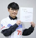 　プロ野球へのメッセージをしたためた色紙を掲げる山口一郎さん＝２０２４年４月４日、名古屋市のバンテリンドームナゴヤ