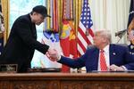 　３０日、米ホワイトハウスでトランプ大統領（右）と握手するイーロン・マスク氏（ゲッティ＝共同）