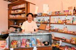 本などが並ぶ店内で「文化を育てたい」と話す大見謝さん＝大山町御来屋