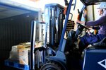 フォークリフトでコンテナに積み込まれる農水産物＝１２日、境港市竹内団地の上組大阪支店境港出張所