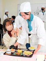 心を込めて作った和定食を保護者へ配膳する生徒