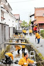 川に入って清掃活動する会員ら